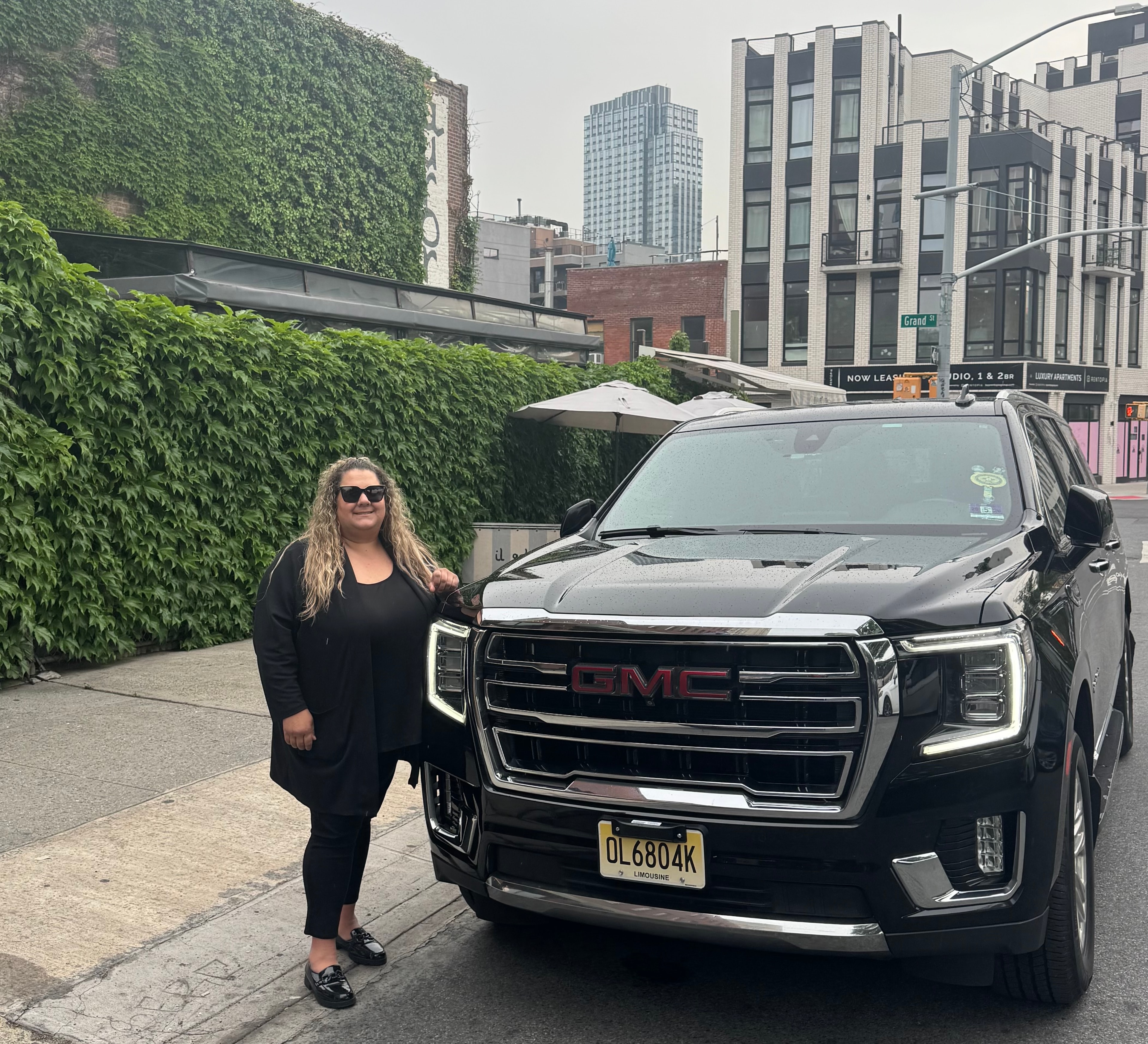 Annie Tarabocchia, Manager of Legacy Limousine, standing beside the 2022 GMC Yukon XL Denali